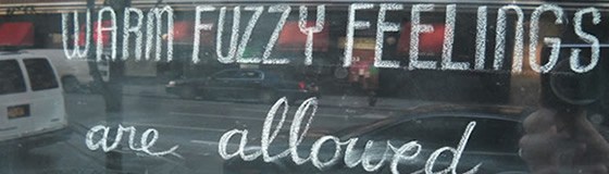 Fuzzy-Marketing A chalkboard with the text "WARM FUZZY FEELINGS are allowed".