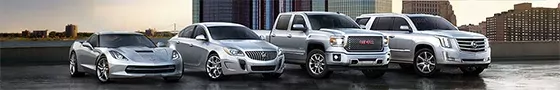general-motors A silver sports car, sedan, ute and SUV are lined up on a building rooftop, with a city skyline in the background.