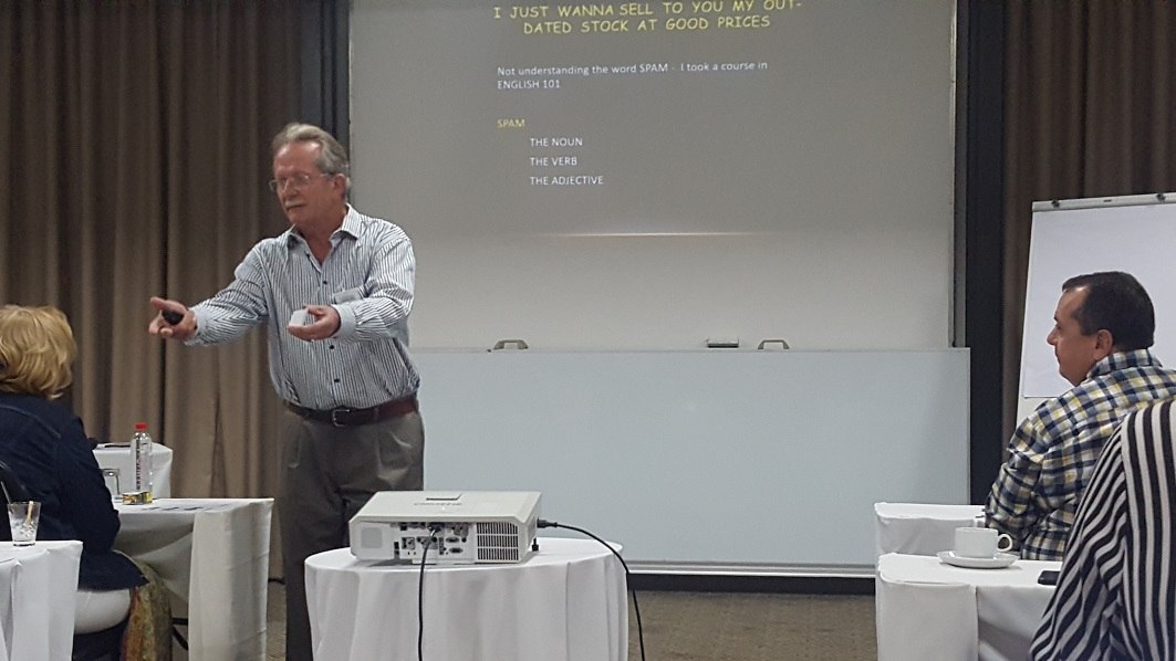 JH Eugene Joubert A man in a shirt addresses a group of people sitting at desks.