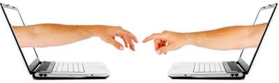 Personal interaction Two hands reach out from laptop screens that sit facing each other.
