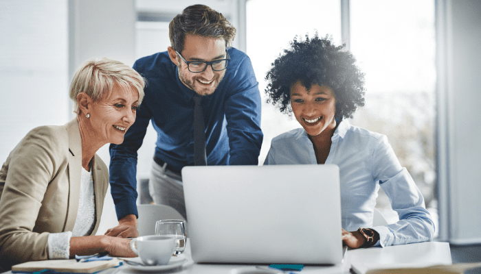 A group of professionals looking at a laptop