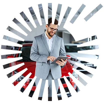 Dealership email branding A guy standing in front of a red car in a dealership, working on his tablet