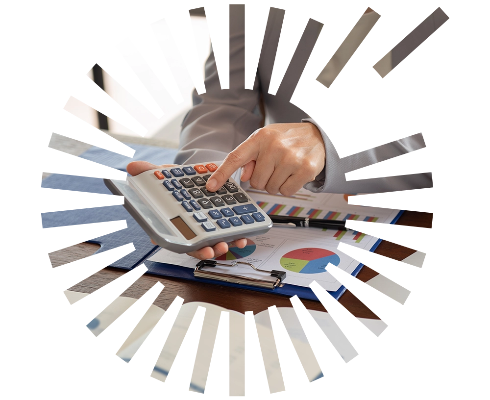 More income A person working on a calculator and a flip file with graphs