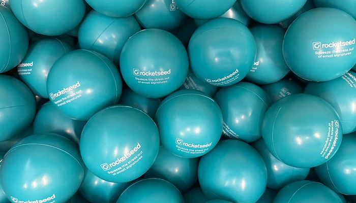 Squeezing the Stress Out of Email Signature Management 5 An image of many blue stress balls with Rocketseed logo and text "Squeeze the stress out of email signatures"